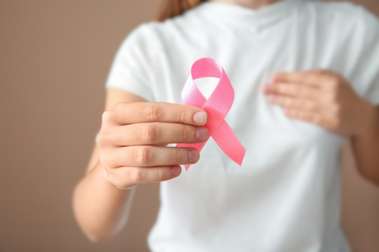 Woman holding a pink ribbon and doing a breast check